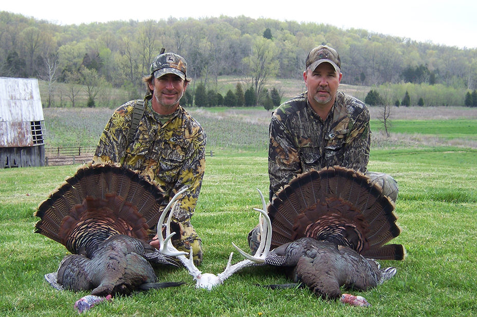 Two men with turkeys pose for a photo at Long Creek Outfitters