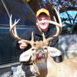 A man poses with his deer at Long Creek Outfitters
