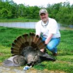 A man poses with his turkey at Long Creek Outfitters