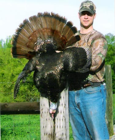 A man holds up a turkey at Long Creek Outfitters